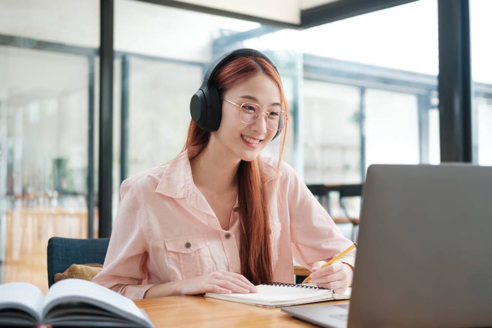Student studying online degree courses in Singapore on laptop and mobile 